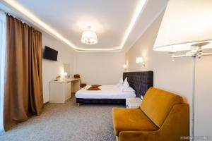 Hotel Aldi في جورا هومورولوي: غرفه فندقيه بسرير وكرسي