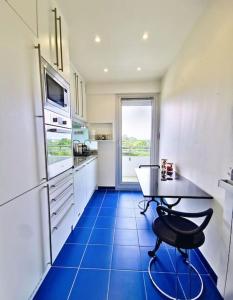 a kitchen with a table and a blue tile floor at « La Canopée » / La Baule view in La Baule