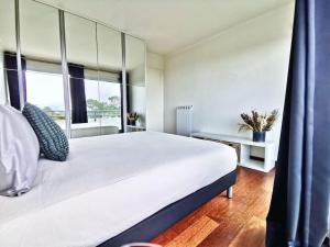 a bedroom with a large white bed and a window at « La Canopée » / La Baule view in La Baule