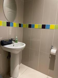 La salle de bains est pourvue d'un lavabo et d'un miroir. dans l'établissement Sermj Abode Nkoyoyo, à Mbabane