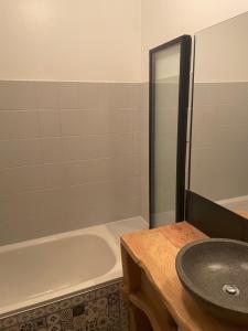 a bathroom with a sink and a bath tub at T2 au coeur de Luchon in Luchon +4 photos