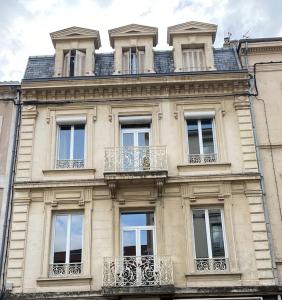 - un grand bâtiment avec des balcons sur le côté dans l'établissement Le Jacquemart, à Romans-sur-Isère