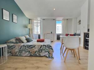 - une chambre avec un lit, une table et une chaise dans l'établissement Le Jacquemart, à Romans-sur-Isère