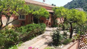 a house with a garden and trees in front of it at Villa Carmelas in Taormina