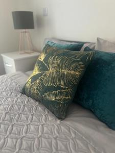 a bed with a black and gold pillow on it at New modern 1 bedroom duplex apartment Hemel Hempstead High Street in Hemel Hempstead