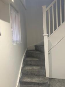 una escalera en una casa con escalera en New modern 1 bedroom duplex apartment Hemel Hempstead High Street, en Hemel Hempstead