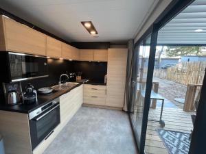 eine Küche mit einer Spüle und einem Herd in der Unterkunft Cottage Jullouville 56 m² tout confort, 6 personnes, 3 chambres, 2 Salles d'eau in Jullouville-les-Pins