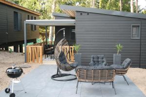 a patio with chairs and a table and a grill at Cottage Jullouville 56 m² tout confort, 6 personnes, 3 chambres, 2 Salles d'eau in Jullouville-les-Pins