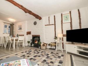 Una sala de estar con chimenea y TV de pantalla plana. en Ocello, en Dartmouth