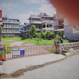 博卡拉的住宿－Hotel Sarathi，建筑物前有标志的栅栏