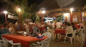 grupa ludzi siedzących przy stolikach w restauracji w obiekcie Breeze Bungalows w mieście Ko Lanta