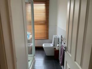 a bathroom with a toilet and a glass shower door at London SW Home in London