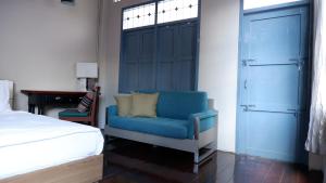 sypialnia z niebieskim krzesłem i łóżkiem w obiekcie Casa Ari - Trang City Center w mieście Trang