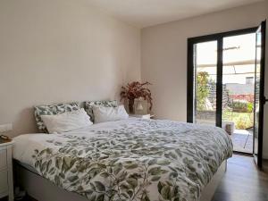 a bedroom with a large bed with a large window at Casa Elena Maresme in Mataró
