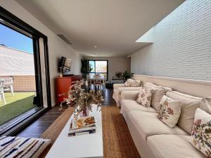 a living room with a white couch and a large window at Casa Elena Maresme in Mataró
