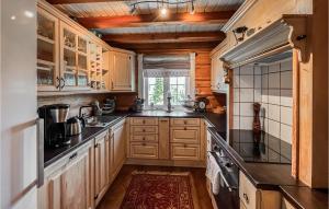 a kitchen with wooden cabinets and a large window at Amazing Home In Svingvoll With 3 Bedrooms in Svingvoll