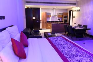 a bedroom with a bed and a living room and a kitchen at Ista Suites Seef in Manama
