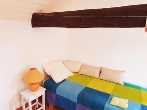 Zimmer mit einem Regenbogenbett und einer Lampe in der Unterkunft Hameau de Leignoua in Le Saint