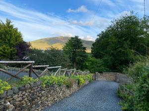 a stone fence and a path with a stone wall at Beech Croft in Keswick