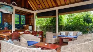 un patio esterno con sedie e tavoli in vimini di Ponder Cottages - The Villa a Nusa Lembongan