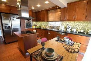 a kitchen with wooden cabinets and a table with chairs at Nefelifamilyhouse with jacuzzi in Lagonissi