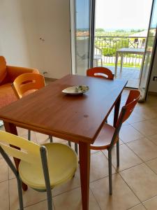 サンタンドレーア・アポストロ・デッロ・イオーニオにあるResidence Il Faroの木製テーブル(椅子、皿付)