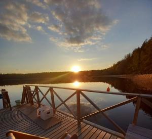 un molo con il sole che tramonta su un lago di Kampus Sippola a Sippola Altre 35 foto