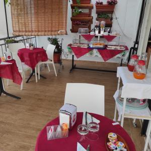 une salle avec des tables, des chaises et un tissu de table rouge dans l'établissement B&B Leonida, à Tropea
