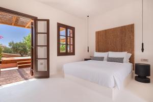 a bedroom with a white bed and a large window at Akre Hotel in Naxos Chora