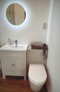 a bathroom with a toilet and a sink and a mirror at The Perch in Bridgend