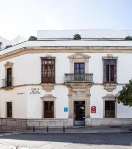 a large white building with windows on a street at Ritual Alameda Sevilla in Seville