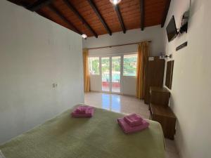 a bedroom with a bed with two purple towels on it at Miltos Studios in Paleokastritsa