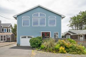 a blue house with a red door at Sandpiper Beach House in Cannon Beach