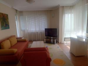 a living room with a couch and a flat screen tv at Стая in Vidin