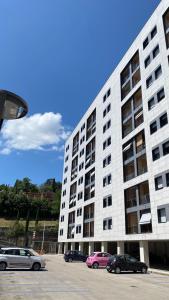 a large white building with cars parked in a parking lot at Casa Valentina 2 in Perugia