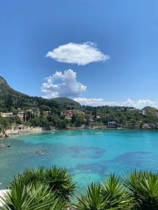 a view of a beach with blue water and trees at Miltos Studios in Paleokastritsa
