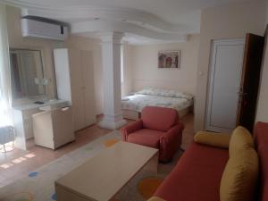 ein Wohnzimmer mit einem Bett und einem roten Sofa in der Unterkunft Стая in Widin