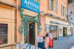 a woman standing in front of a store with luggage at Aparthotel AMMI Vieux Nice in Nice +37 photos