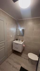 a bathroom with a white toilet and a sink at Appartement privé « Rive Droite » in Serrières +16 photos