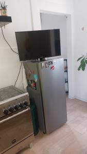 TV en la parte superior de una nevera en la cocina en L'appartamentino, en Reggio Calabria