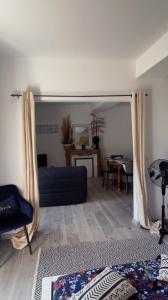 sala de estar con sofá azul y mesa en Appartement privé « Rive Droite », en Serrières