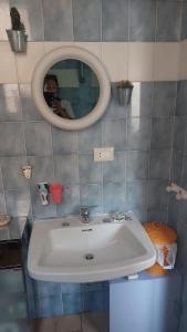 bagno con lavandino bianco e specchio di L'appartamentino a Reggio di Calabria