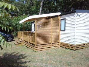 a small wooden cabin with a roof at Mobil home Neuf 6 places Climatisé in Camiers +6 photos