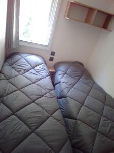 a bed in a small room with a window at Mobil home Neuf 6 places Climatisé in Camiers