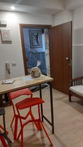 una stanza con un tavolo e due sedie rosse di L'appartamentino a Reggio di Calabria