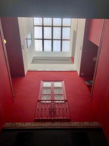 Habitación roja con ventana y suelo rojo. en Ritual Alameda Sevilla, en Sevilla