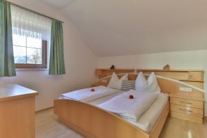 a bedroom with a bed with white pillows and a window at Jörgishof in Untertscheltsch