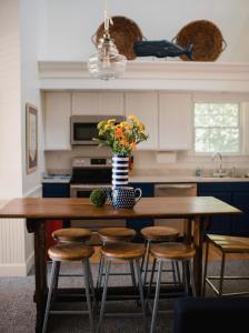 una cocina con una mesa con sillas y un jarrón de flores en Chapman House en Put-in-Bay