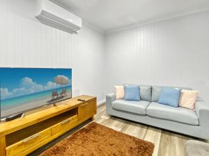 un salon avec un canapé et une télévision à écran plat dans l'établissement Magnetic Reef Unit 2, à Arcadia