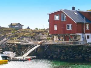 バルスタにあるTwo-Bedroom Holiday home in Ballstad 1の赤い家と水上船